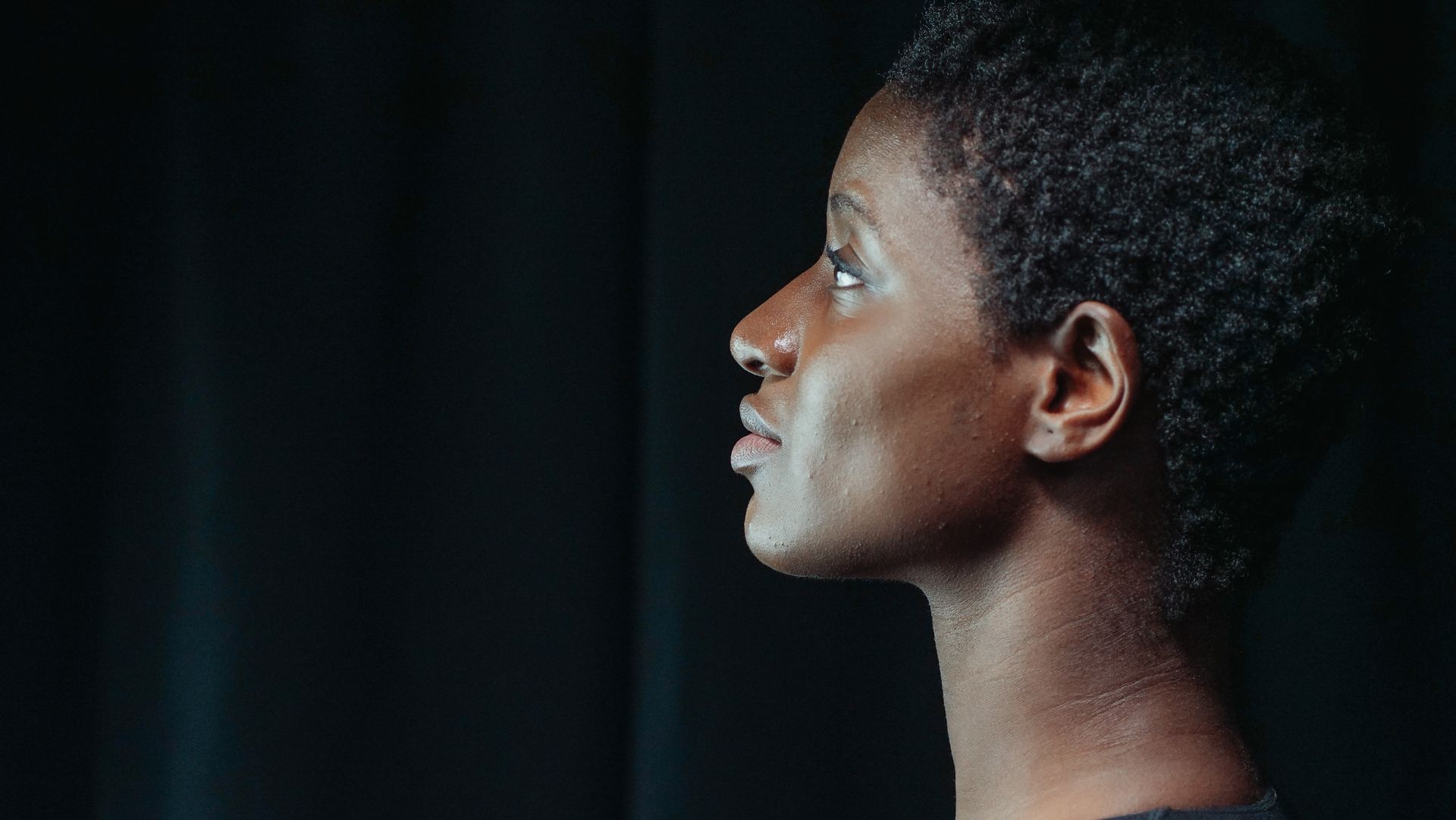Une jeune femme, de profil, dans la lumière