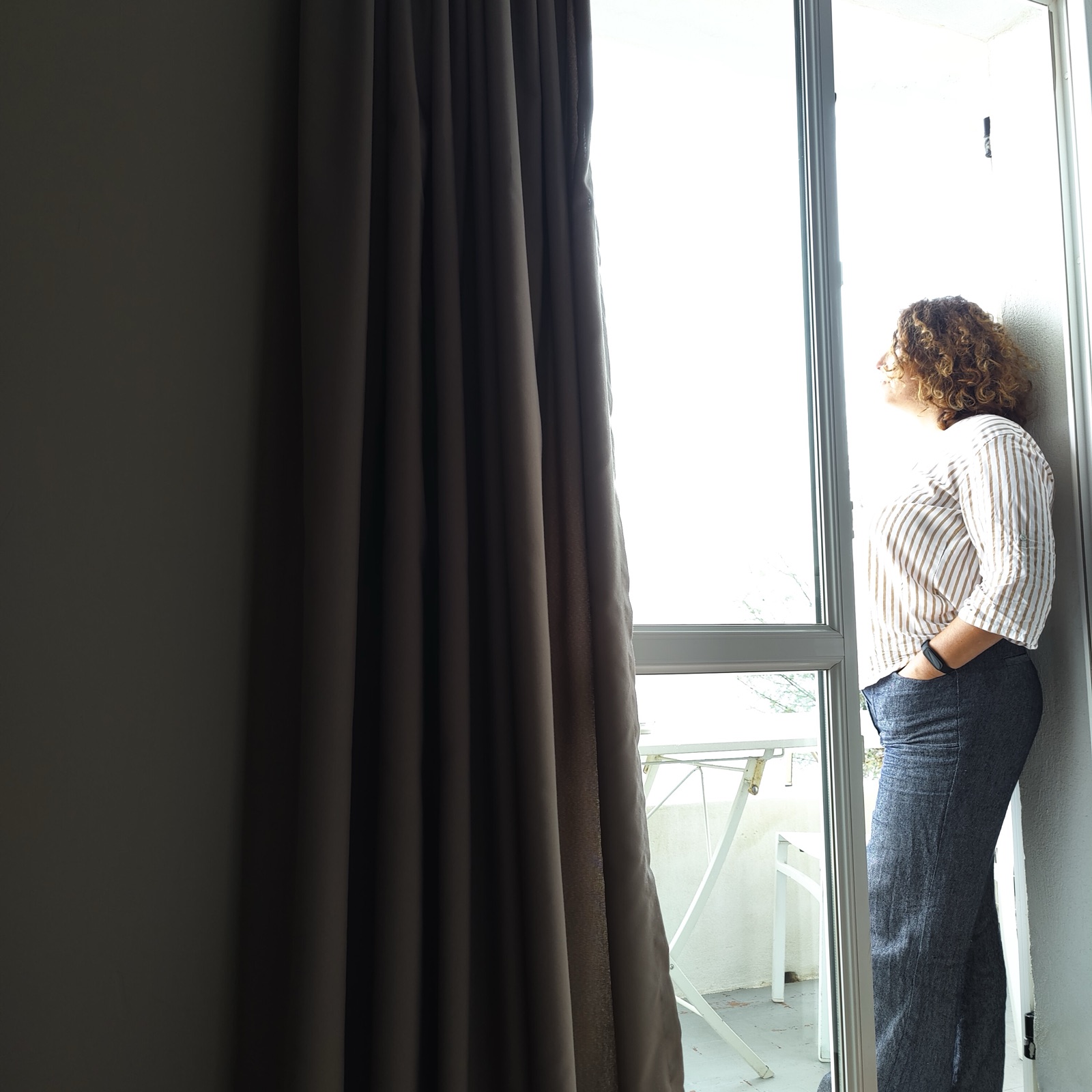 Une femme, de profil, à la fenêtre
